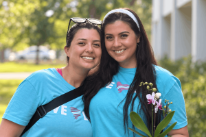 Two women in Love Life shirts stand together outdoors