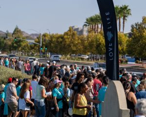 Prayer walk gathering beside a Love Life banner