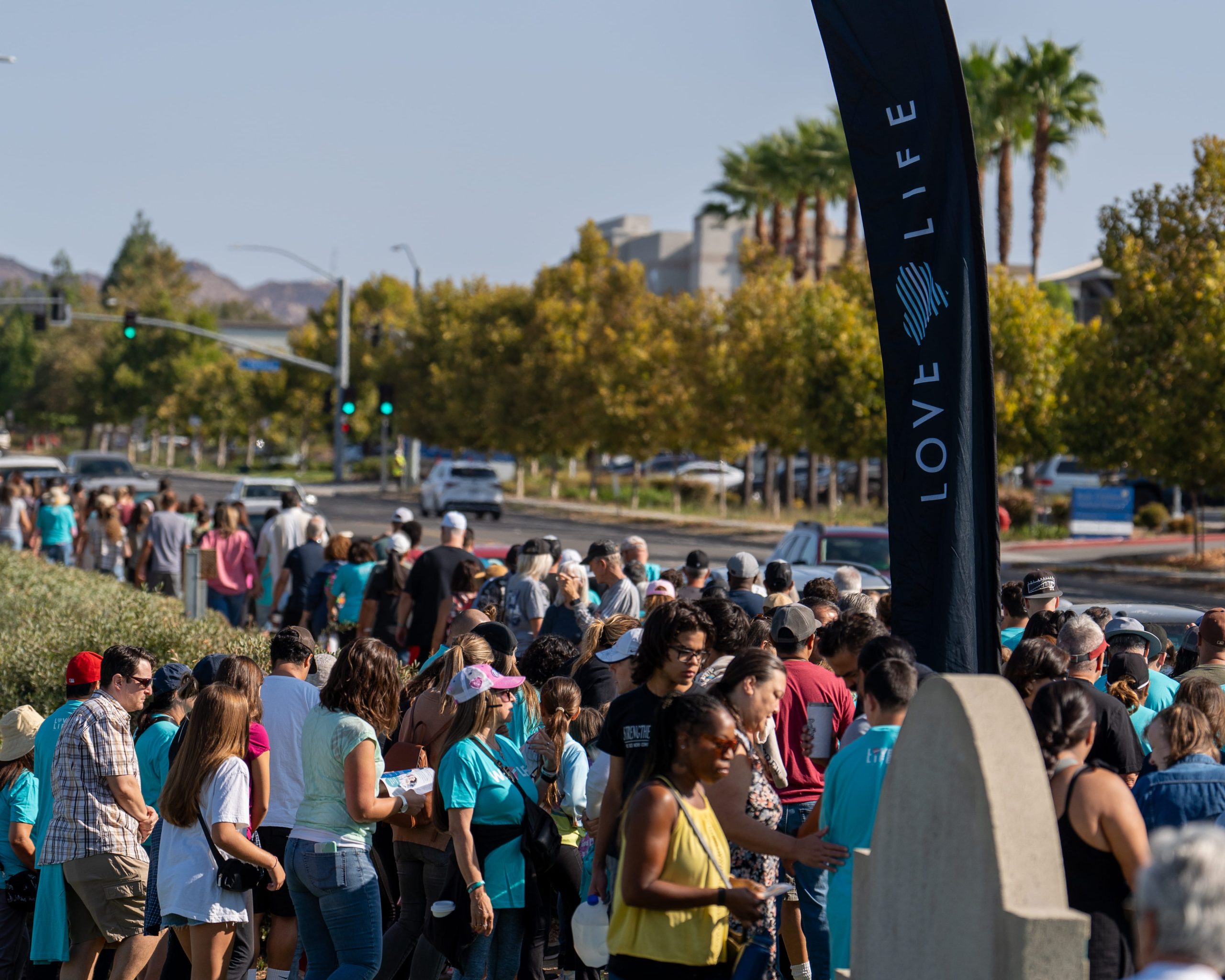 Prayer walk gathering beside a Love Life banner